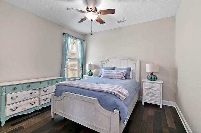 bedroom featuring visible vents, ceiling fan, baseboards, dark wood finished floors, and a textured ceiling