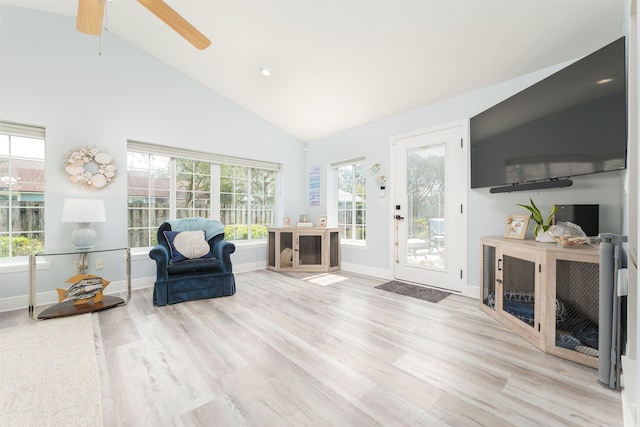 living area featuring high vaulted ceiling, baseboards, and wood finished floors