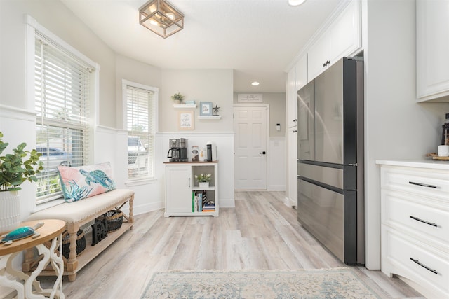 interior space with recessed lighting, white cabinetry, wainscoting, light wood-type flooring, and freestanding refrigerator