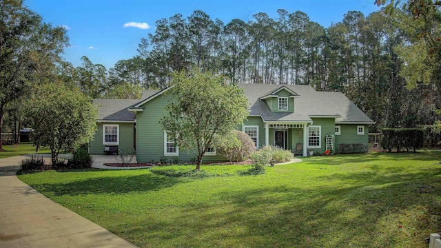 view of front of home with roof with shingles and a front yard