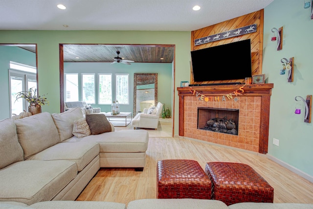 living area featuring a ceiling fan, recessed lighting, a fireplace, and wood finished floors