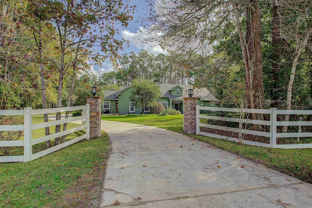 view of gate with a yard and a fenced front yard