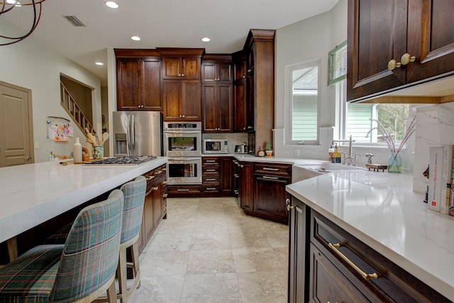 kitchen with recessed lighting, a sink, visible vents, appliances with stainless steel finishes, and decorative backsplash