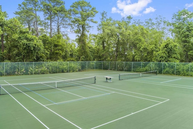 view of tennis court featuring fence