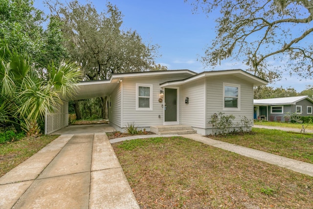 bungalow-style house featuring a carport and a front lawn