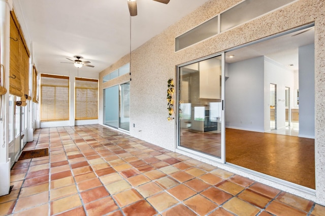 unfurnished sunroom featuring ceiling fan