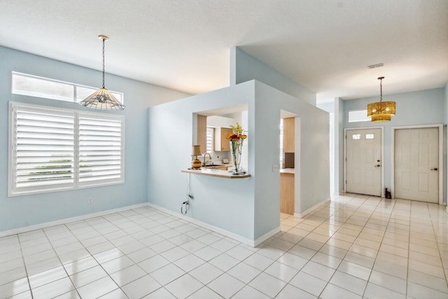 entryway featuring a textured ceiling, light tile patterned floors, and sink