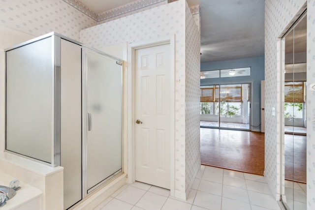 bathroom with tile patterned flooring, a shower with shower door, and a textured ceiling