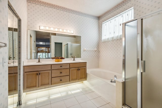 bathroom with tile patterned floors, vanity, a textured ceiling, and plus walk in shower