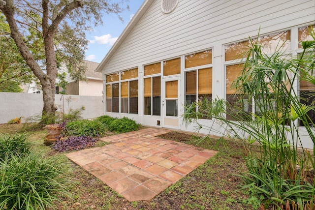 back of property featuring a sunroom and a patio