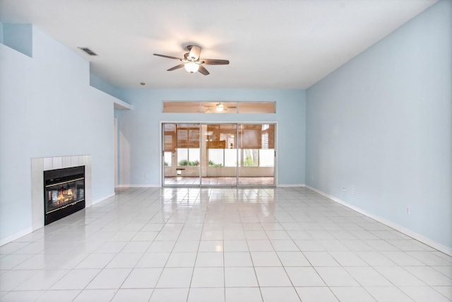 unfurnished living room featuring ceiling fan, a fireplace, and light tile patterned floors