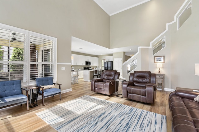 1125 S Marsh Wind Way, Ponte Vedra Beach, FL 32082 - living area with baseboards, ornamental molding, light wood-style flooring, and a towering ceiling
