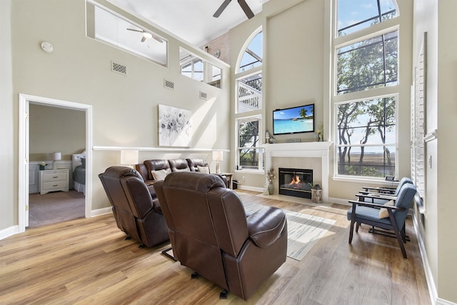 1125 S Marsh Wind Way, Ponte Vedra Beach, FL 32082 - living area with a high ceiling, light wood-style flooring, a ceiling fan, a tile fireplace, and visible vents