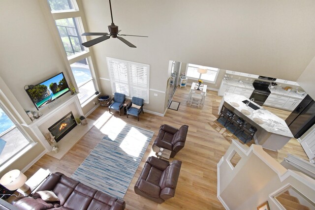 1125 S Marsh Wind Way, Ponte Vedra Beach, FL 32082 - living area with a glass covered fireplace, wood finished floors, and a towering ceiling