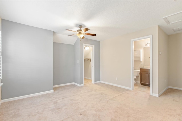 empty room featuring ceiling fan, light colored carpet, and a textured ceiling