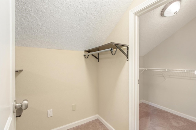 spacious closet with lofted ceiling and carpet