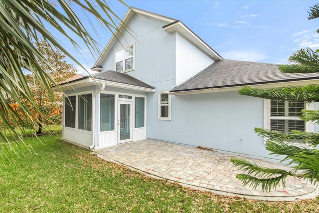 back of house with a patio area, a sunroom, and a lawn