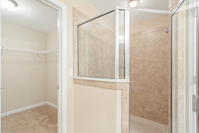 bathroom with a tile shower and a textured ceiling