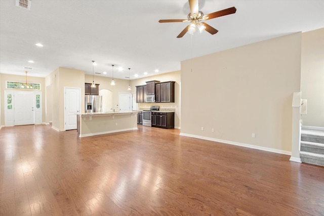 unfurnished living room featuring dark hardwood / wood-style flooring and ceiling fan