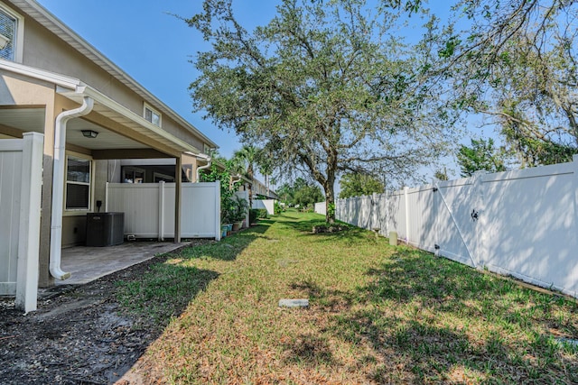 view of yard with central AC and a patio