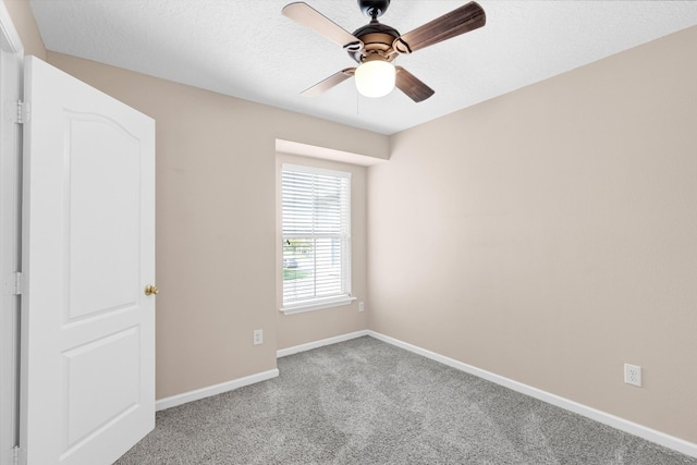 carpeted empty room with ceiling fan and a textured ceiling