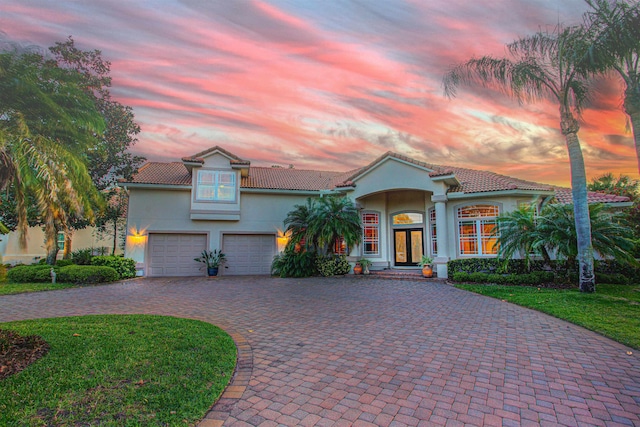413 Fiddlers Point Dr, Saint Augustine, FL 32080 - mediterranean / spanish-style house with french doors, decorative driveway, stucco siding, a tiled roof, and an attached garage