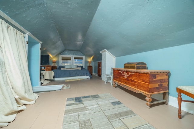 bedroom featuring vaulted ceiling and hardwood / wood-style flooring