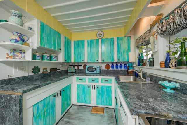 kitchen with sink, dishwashing machine, and beam ceiling