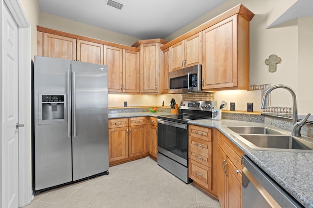 kitchen featuring appliances with stainless steel finishes, sink, and light tile patterned floors