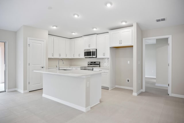 kitchen featuring appliances with stainless steel finishes, a kitchen island with sink, sink, and white cabinets