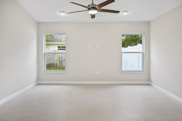 tiled spare room with ceiling fan