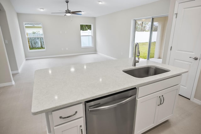 kitchen with dishwasher, sink, white cabinets, and light stone counters