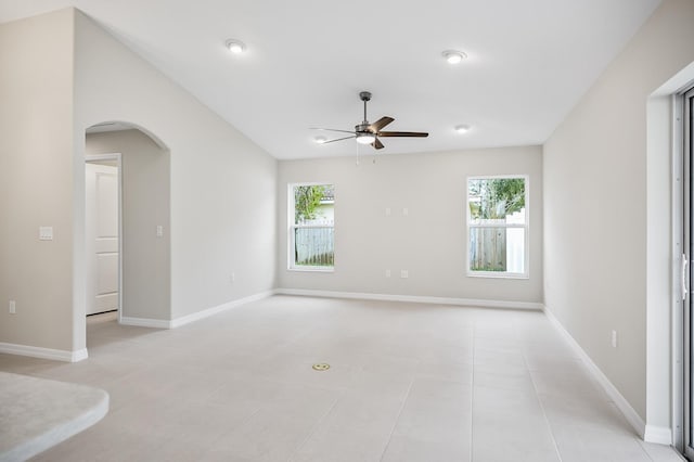 tiled empty room with ceiling fan and a healthy amount of sunlight