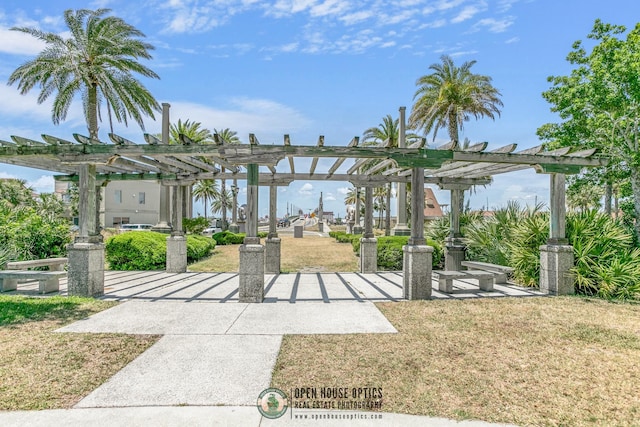 view of home's community with a pergola and a lawn