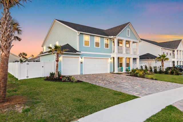 view of front of property featuring a gate, fence, an attached garage, a front yard, and decorative driveway