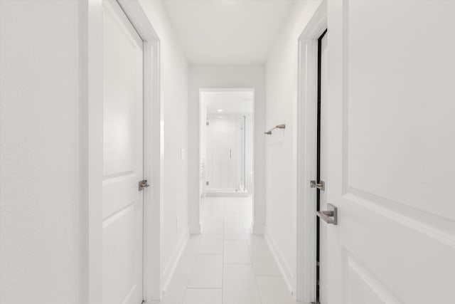 hallway with baseboards and light tile patterned flooring