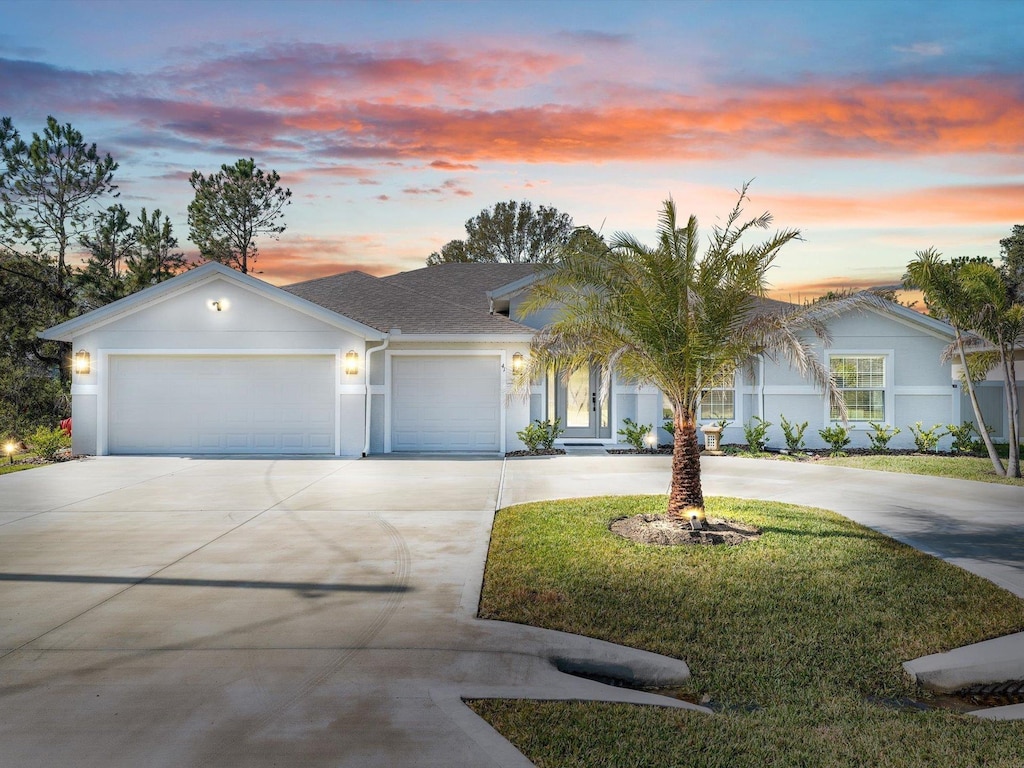 view of front facade featuring a lawn and a garage