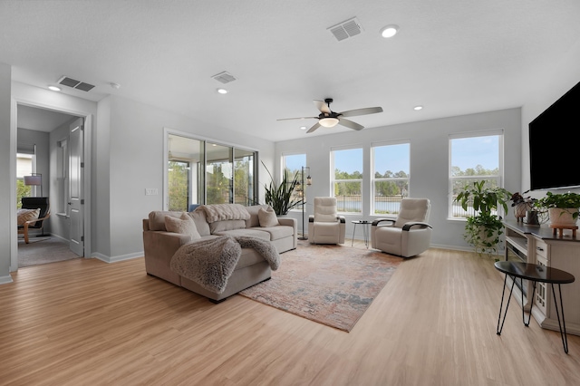 living room with visible vents, baseboards, and light wood-type flooring