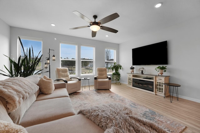 living area with recessed lighting, baseboards, and wood finished floors