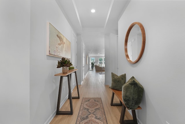 hall featuring light wood finished floors, recessed lighting, and baseboards