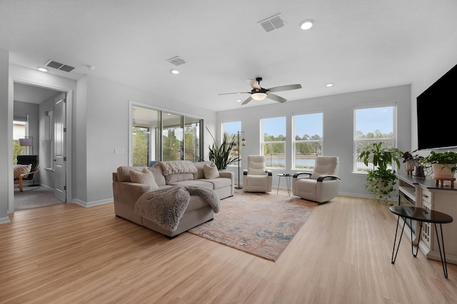 living area with visible vents, light wood-style flooring, and baseboards