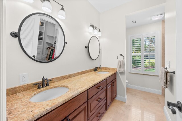 248 Marshside Dr, Saint Augustine, FL 32080 - bathroom with double vanity, baseboards, toilet, tile patterned flooring, and a spacious closet