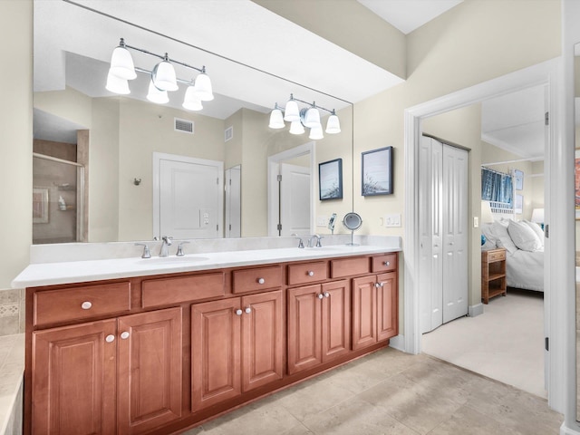 ensuite bathroom with ensuite bathroom, a sink, visible vents, a shower stall, and double vanity