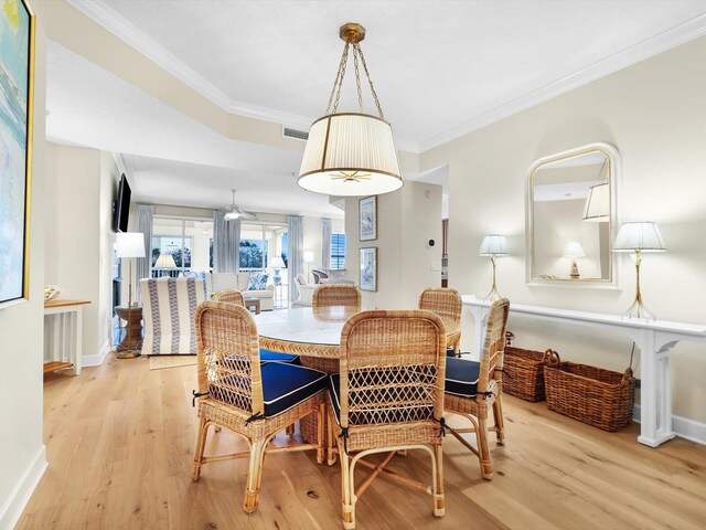 dining space featuring ornamental molding, visible vents, and light wood finished floors