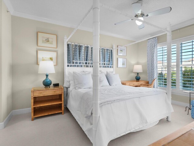 bedroom featuring carpet floors, ornamental molding, a ceiling fan, and baseboards