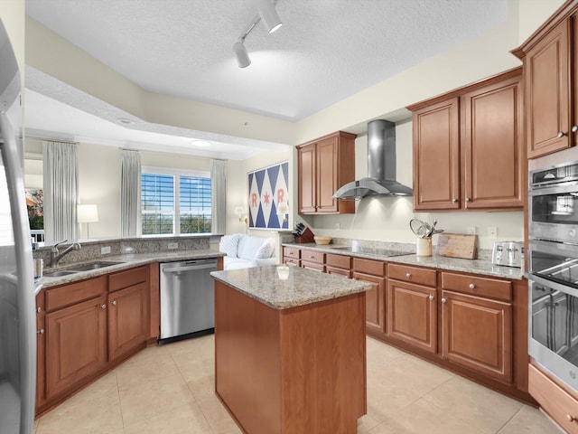 kitchen with black electric stovetop, stainless steel dishwasher, a sink, light stone countertops, and wall chimney exhaust hood