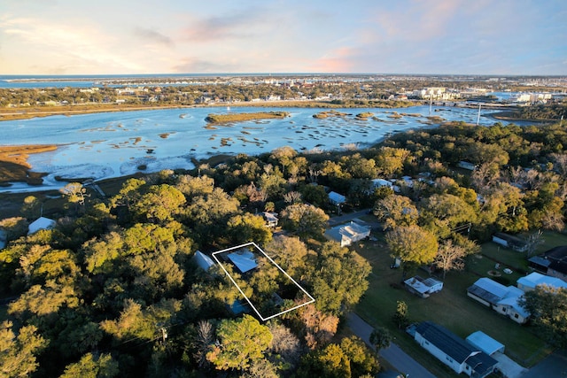 aerial view at dusk featuring a water view