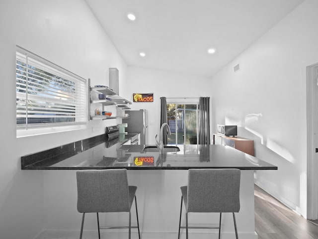 kitchen with stainless steel appliances, sink, a kitchen bar, and kitchen peninsula