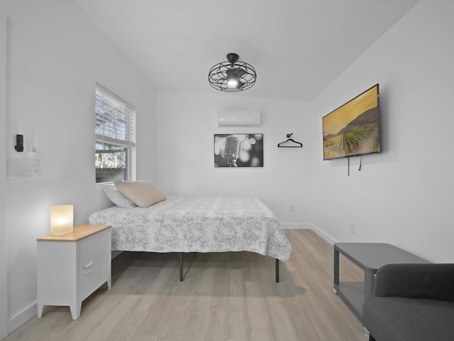 bedroom featuring a wall mounted air conditioner and light hardwood / wood-style floors