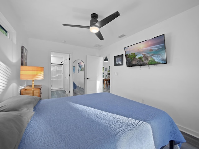 bedroom with ceiling fan, wood-type flooring, and ensuite bath